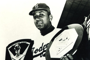 Don Newcombe holds the double honors presented to him in 1956 with the Cy Young Award in his right arm and the 1956 National League Most Valuable Player Award.