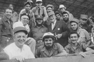 (Front Row, 1st person, Gabe Paul, general manager of the Cincinnati Reds; 2nd row, 2nd person from the left, Bud Holman; 2nd row, 4th person from the left, Walter O’Malley) Dodger President Walter O’Malley, with Cincinnati Reds’ general manager Gabe Paul and prominent Vero Beach businessman Bud Holman, are photographed with Cuban military personnel at the El Gran Estadio ballpark in Havana, Cuba.