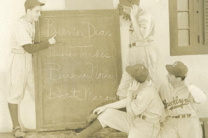 (Upper left corner, Julio (Monchy) DeArcos; Upper right corner, Pee Wee Reese; Lower right corner (L-R) Johnny Hudson; Charlie Gilbert. Julio (Monchy) DeArcos, a friend of Dodger Manager Leo Durocher in Cuba, provides a fundamental lesson in Spanish for Dodger players